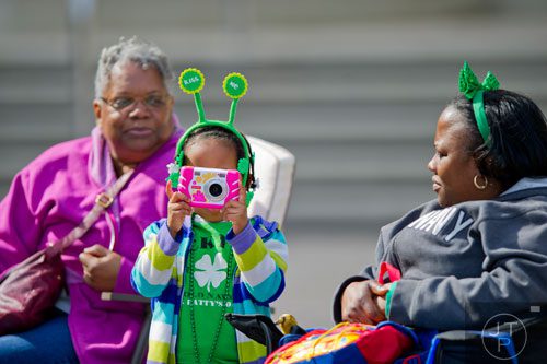 Riley Grace Braithwaite takes a photo with her camer as she waits for the Atlanta St. Patrick's Day Parade to begin on Saturday, March 15, 2014. 