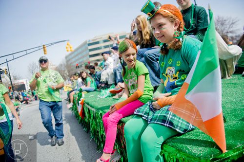 Erin McGrath (right) and Allison Riley ride a float down Peachtree St. during the Atlanta St. Patrick's Day Parade on Saturday, March 15, 2014. 