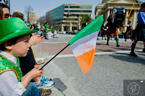 Ronan Wrenn (left) watches the Atlanta St. Patrick's Day Parade pass by on Peachtree St, on Saturday, March 15, 2014. 