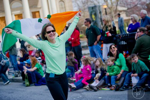 Mary Long (left) holds up an Irish flag as she walks down Peachtree St. during the Atlanta St. Patrick's Day Parade on Saturday, March 15, 2014. 