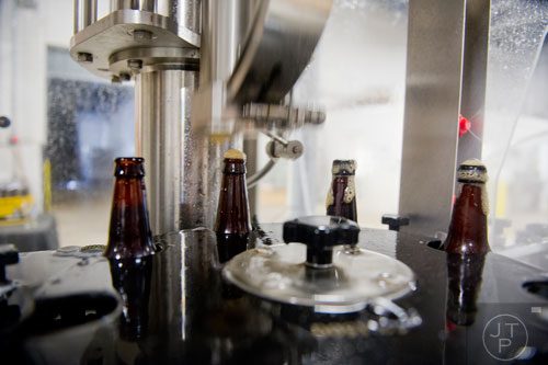 Beer bottles circulate through the bottling machine at Monday Night Brewing in Atlanta on Tuesday, February 18, 2014.