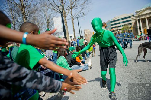 Owen McClelland (right) hands out high fives during the Atlanta St. Patrick's Day Parade on Saturday, March 15, 2014.