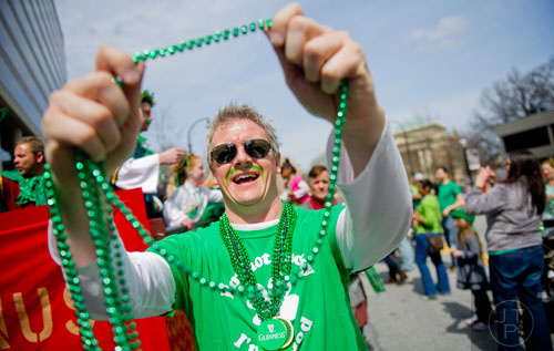Bill Ford hands out green beaded necklaces during the Atlanta St. Patrick's Day Parade on Saturday, March 15, 2014. 