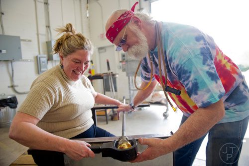 Allen Bush (right) teaches Allison Hawkins how to make glass art during a demonstration at Atlanta Hot Glass during the Rail Arts District's Art Cruise on Saturday, March 15, 2014.