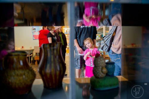 Kaydence Spangler (right) looks at some of the pottery at MudFire Pottery Gallery as she walks around with her family during the Rail Arts District's Art Cruise on Saturday, March 15, 2014.