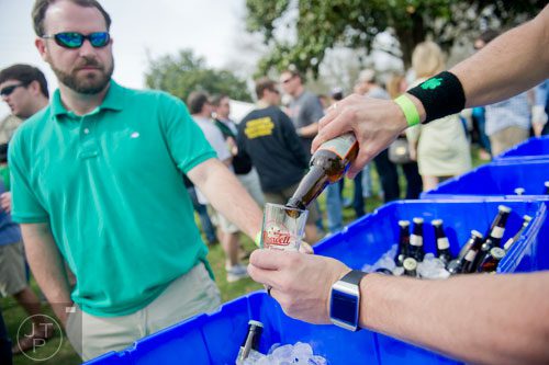 C.J. Kell (right hands) pours a beer for Jeff Norris during the Roswell Beer Festival & Cornhole Tournament at historic Roswell square on Saturday, March 15, 2014.
