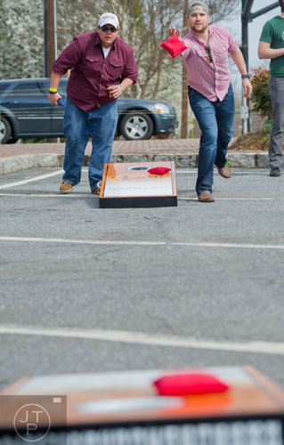 Zach Sines (left) and Michael Curling play a game of cornhole during the Roswell Beer Festival & Cornhole Tournament at historic Roswell square on Saturday, March 15, 2014. 