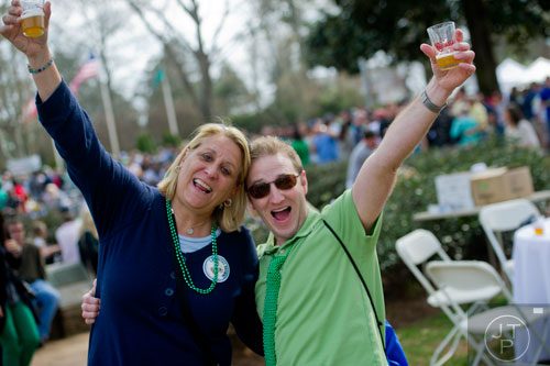 Jill Contarino (left) and Wesley Dickens lift up their glasses and scream during the Roswell Beer Festival & Cornhole Tournament at historic Roswell square on Saturday, March 15, 2014. 