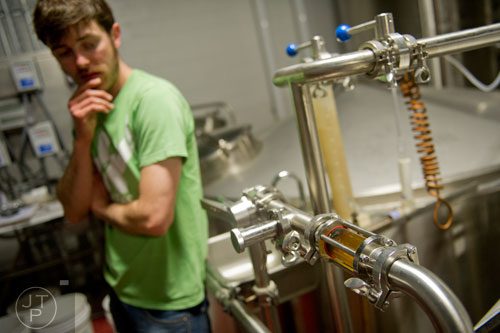 Adam Bishop glances at one of the lines of beer as he brews at Monday Night Brewing in Atlanta on Thursday, February 20, 2014. 