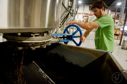 Adam Bishop empties a kettle of used grain at Monday Night Brewing in Atlanta on Thursday, February 20, 2014. 
