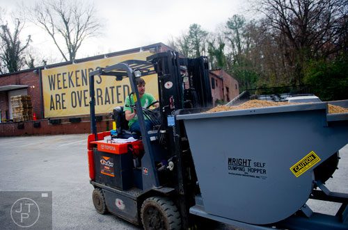 Adam Bishop uses a forklift to carry a container of used grain at Monday Night Brewing in Atlanta on Thursday, February 20, 2014. 