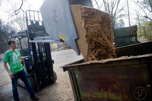 Adam Bishop dumps a container of used grain at Monday Night Brewing in Atlanta on Thursday, February 20, 2014. 