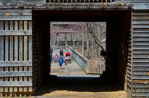 Ethan Rollins (front) leads his sister Abigail and mother Kristina scross the bridge at McDaniel Farm Park in Duluth on Thursday, March 20, 2014. 