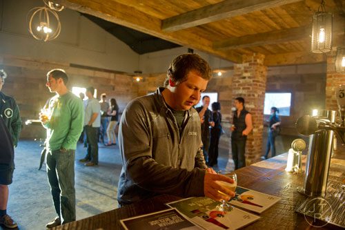 Chris Hess grabs a beer from the bar at Three Taverns Craft Brewery in Decatur on Friday, February 21, 2014. 
