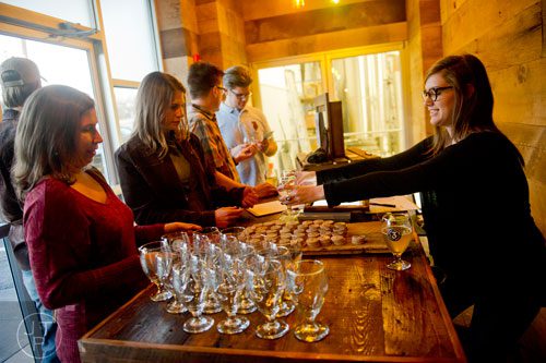 Sarah Spear (right) hands glasses to Lisa Krajewski and Kathy Hewitt (left) at Three Taverns Craft Brewery in Decatur on Friday, February 21, 2014. 
