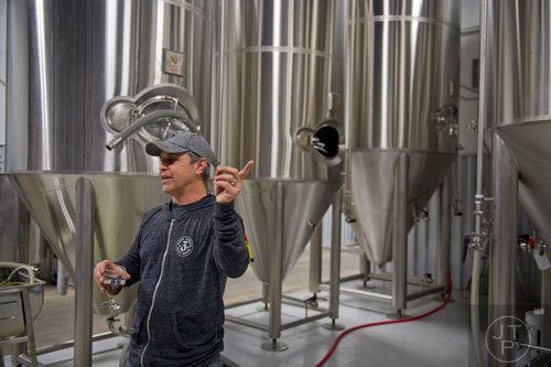 Brian Purcell, owner and brewmaster at Three Taverns Craft Brewery in Decatur, talks to a group of people during a tour on Friday, February 21, 2014. 