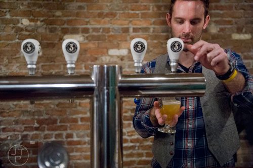 J.V. Gortney pours a beer at Three Taverns Craft Brewery in Decatur on Friday, February 21, 2014. 