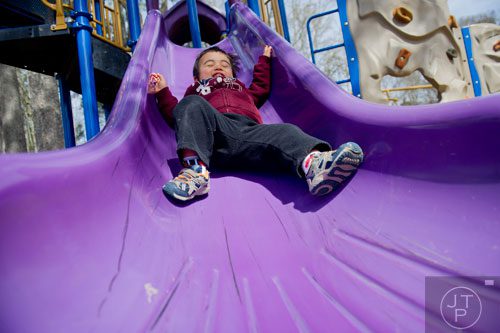 Benjamin Kim zooms down one of the slides on the playground at Glenlake Park in Decatur on Friday, March 21, 2014. 