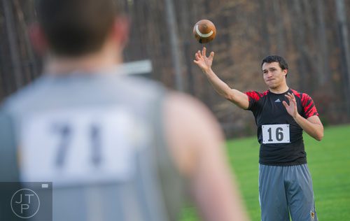 Tyler Cantrell (right) tosses a football to Jonathan Pritchett during the first tryouts for the new Kennesaw State University football team at The Perch on campus on Saturday, March 22, 2014. 