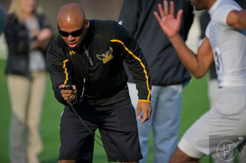 Wide receiver coach Mike Daniels (left) checks his stopwatch for the 40 meter dash portion of the first tryouts for the new Kennesaw State University football team at The Perch on campus on Saturday, March 22, 2014. 