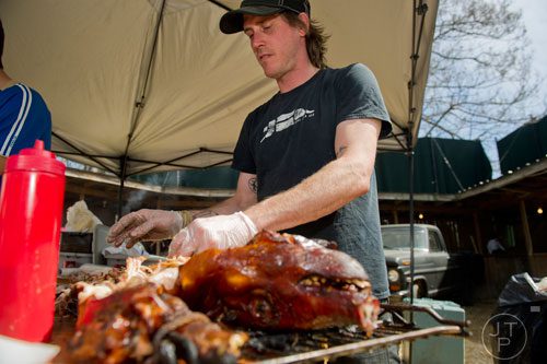 Mike LaSage pulls meat off of a cooked pig during the Hogs and Hops festival at the Masquerade in Atlanta on Saturday, April 5, 2014. 