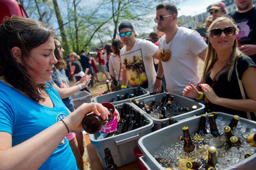 Kelly Parry (left) pours a beer during the Hogs and Hops festival at the Masquerade in Atlanta on Saturday, April 5, 2014. 