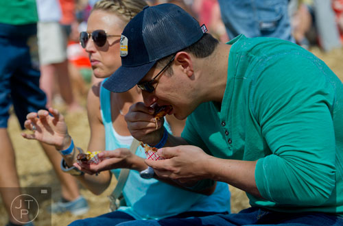 Ray Simmons (right) and his wife Megan taste some of the barbeque during the Hogs and Hops festival at the Masquerade in Atlanta on Saturday, April 5, 2014. 