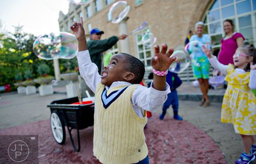 Elijah Simmons reaches up to try and pop bubbles during the Fernbank Museum of Natural History's Dinosaur Egg Hunt in Atlanta on Saturday, April 12, 2014. 