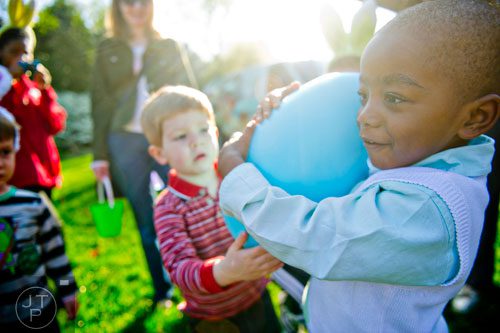 Nigel Hollis (right) carries a giant egg as he hands it off to Tyson Cook during the Fernbank Museum of Natural History's Dinosaur Egg Hunt in Atlanta on Saturday, April 12, 2014. 