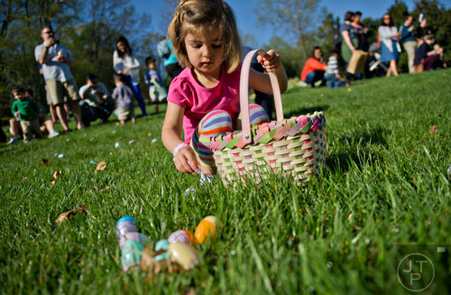 Emma Hart (center) pics up eggs to put in her basket during the Fernbank Museum of Natural History's Dinosaur Egg Hunt in Atlanta on Saturday, April 12, 2014. 