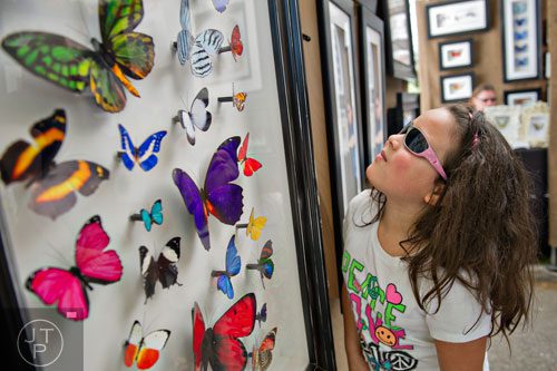 Alexis Turner looks at the artwork on display in Jennifer Ivory's booth during the 78th Annual Atlanta Dogwood Festival at Piedmont Park on Saturday, April 12, 2014. 