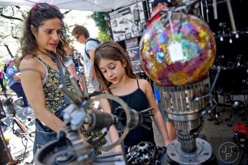 Julie Zeff (left) and her daughter Sarah look at the artwork on display in Richard Kolb's booth during the 78th Annual Atlanta Dogwood Festival at Piedmont Park on Saturday, April 12, 2014. 