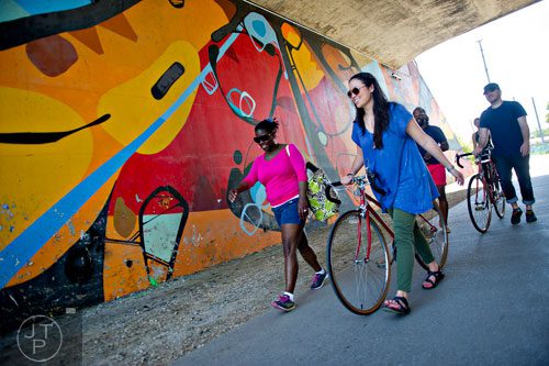Erin Wood (right) walks her bike next to Evonne Woodson as they make their way down the path along the Atlanta Beltline Trail on Saturday, April 12, 2014.   