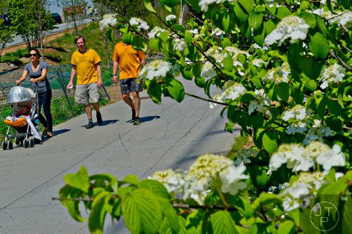 Stacy Imler (left) pushes her son Quincy in a stroller as she talks to Bryan Marshall and his brother Todd as they walk down the path along the Atlanta Beltline Trail on Saturday, April 12, 2014. 