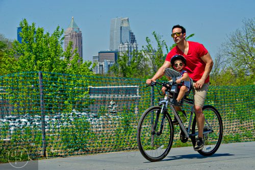 Luis Ahuaji rides his bike down the path along the Atlanta Beltline Trail with his son Shepard on Saturday, April 12, 2014.  