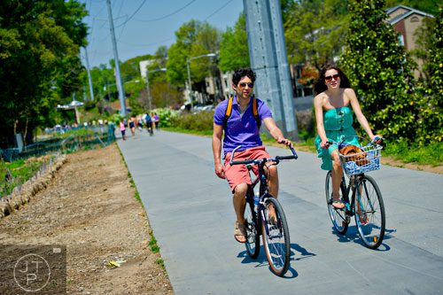 Mariella Handschin (right) talks to Michaelangelo Monteleone as they ride their bikes down the path along the Atlanta Beltline Trail on Saturday, April 12, 2014. 