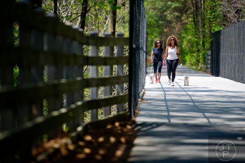 Yashica Marshall (right) and her daughter Chastity walk their dogs down the Silver Comet Trail in Mableton on Saturday, April 12, 2014. 