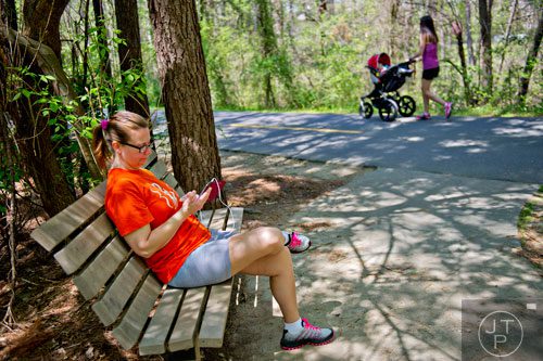Mary Miller (left) listens to a book on tape as she takes a short break from walking down the Silver Comet Trail in Mableton on Saturday, April 12, 2014. 