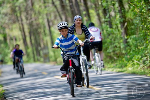Brandon Rodriguez (center) rides his bike down the Silver Comet Trail in Mableton on Saturday, April 12, 2014. 