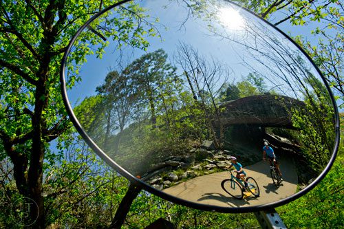 Zoe Dennis (left) and her father Gary ride their bikes down the path of the Big Creek Greenway in Alpharetta on Saturday, April 12, 2014. 