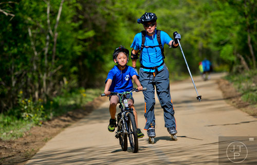 Evan Yun (front) rides his bike as his father Joseph rollerblades next to him down the path of the Big Creek Greenway in Alpharetta on Saturday, April 12, 2014. 