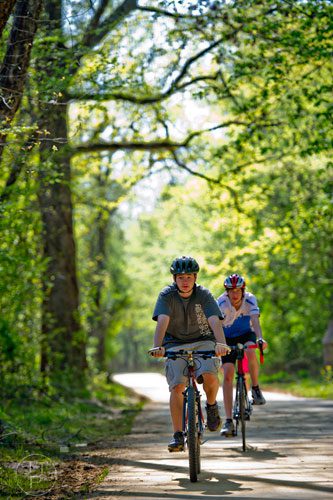 Owen West (front) and John Schlarb ride their bikes down the path of the Big Creek Greenway in Alpharetta on Saturday, April 12, 2014. 