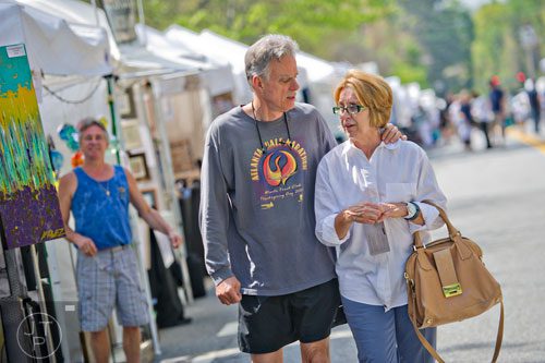 Jack Appleton (left) and his wife Kathy walk past the artist booths on Lake Forrest Dr. during the Sandy Springs Artsapalooza on Sunday, April 13, 2014. 