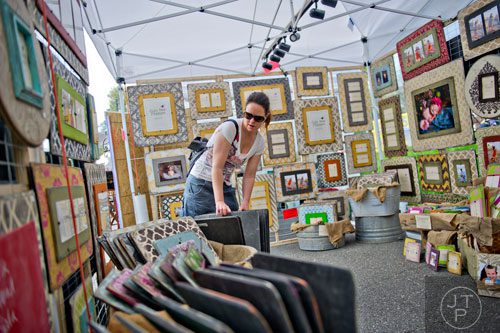Claire Thurber looks at picture frames in Leisha Allen's booth during the Sandy Springs Artsapalooza on Sunday, April 13, 2014. 