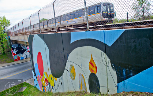 A MARTA train passes over the mural at the corner of Dekalb Ave. and Arizona Ave. on Thursday, April 17, 2014.