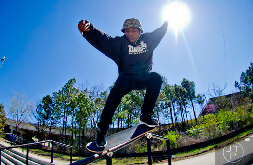 Malik Jones slides down a rail as he rides his board at the Historic Fourth Ward Skatepark in Atlanta on Wednesday, March 26, 2014.