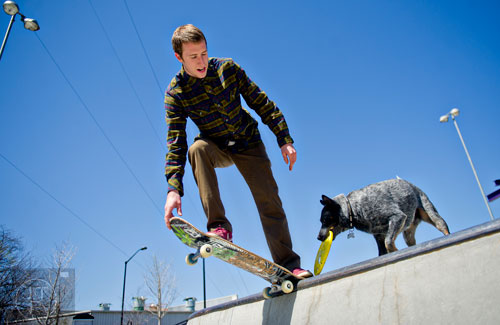 Pro skater Grant Taylor dips into a bowl on his board as his Australian Shepherd Ozzy wtches from the rim at the Historic Fourth Ward Skatepark in Atlanta on Wednesday, March 26, 2014. 