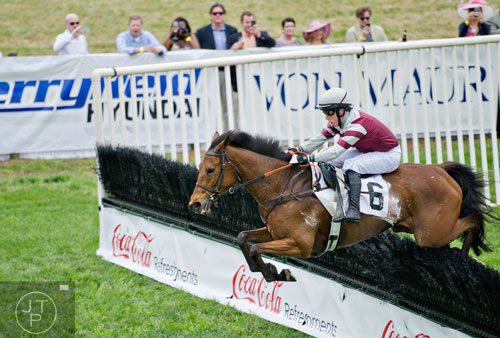 Jockey Harry Haynes rides Hiwasee Gem as they clear a hurdle in the Coca-Cola Refreshments Georgia Cup during the 49th Annual Running of the Atlanta Steeplechase At Kingston Downs in Rome on Saturday, April 19, 2014. 