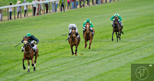 Jockey Robert Walsh (left) rides Kisser N Run as they lead the field towards the finish line in the Coca-Cola Refreshments Georgia Cup during the 49th Annual Running of the Atlanta Steeplechase At Kingston Downs in Rome on Saturday, April 19, 2014. 