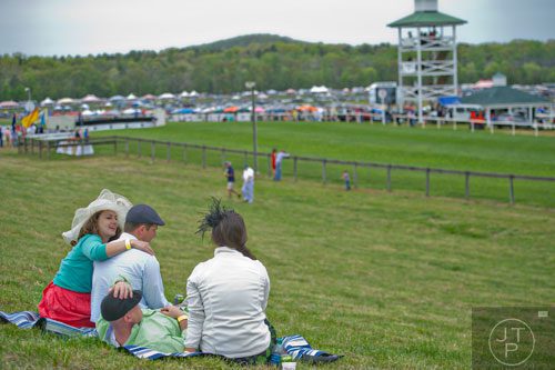 Anna Newton -Levinson (left) puts her arm around Josh Wells as they sit with Todd Hunter and his wife Vanessa during the 49th Annual Running of the Atlanta Steeplechase At Kingston Downs in Rome on Saturday, April 19, 2014. 